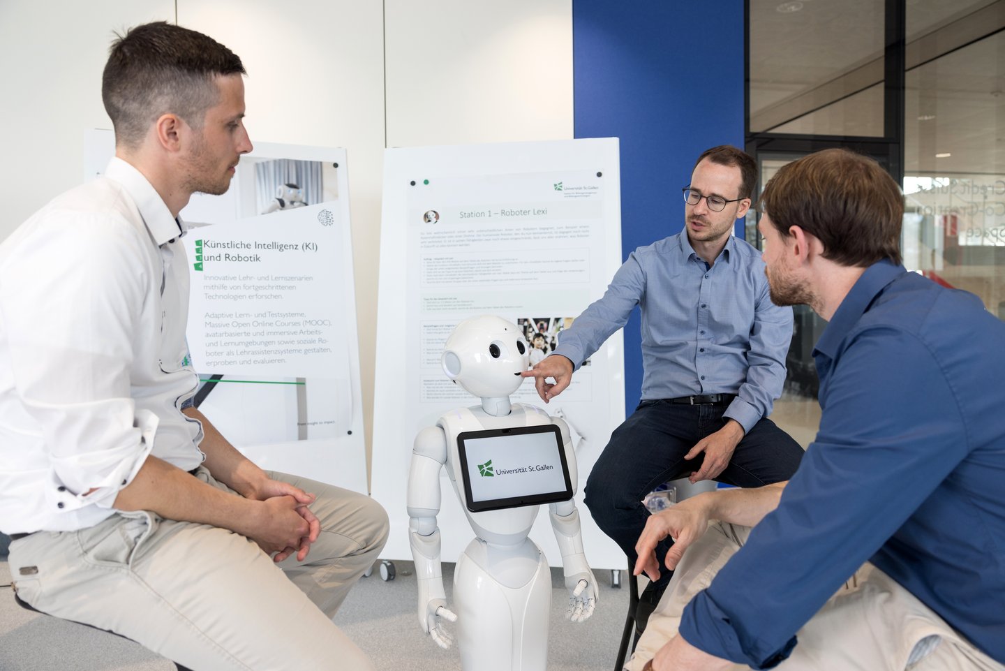 Mitarbeitende des IBB-HSG interagieren mit dem Sozialroboter "Lexi"